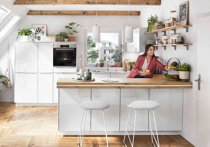 Helle Dachgeschossküche in Weiß mit Holzarbeitsplatte und moderner Einrichtung